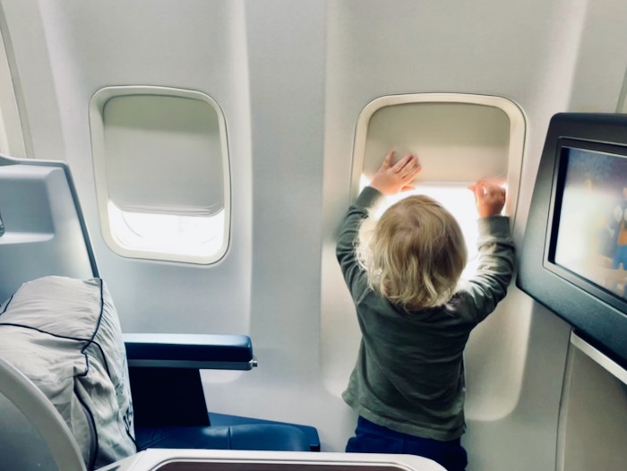 Toddler playing with airplane windowshade