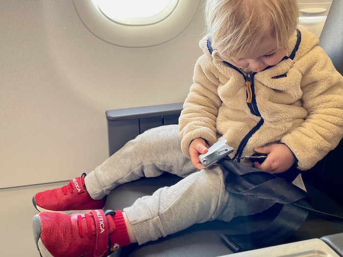 Toddler buckling airplane seatbelt