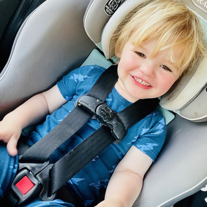 Toddler smiling in car seat
