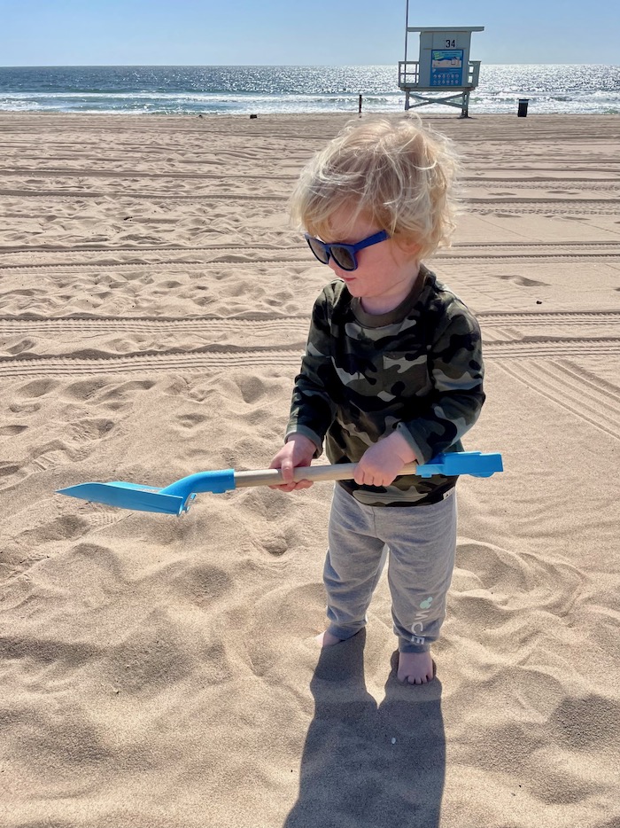 Toddler shoveling sand