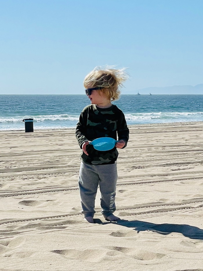 Toddler in warm clothes at the beach