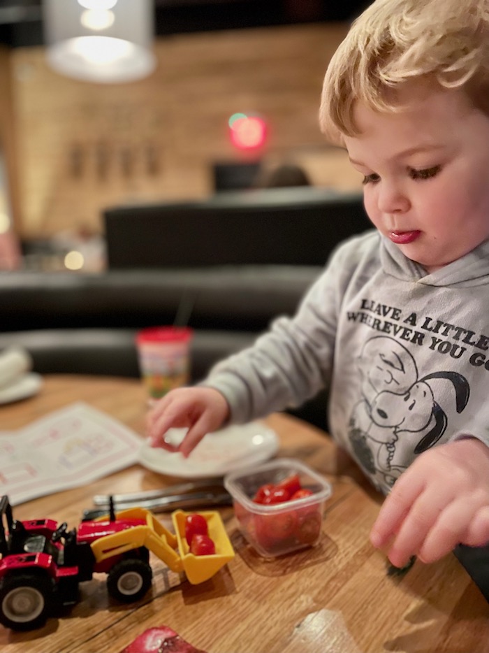 Toddler with toy truck at restaurant