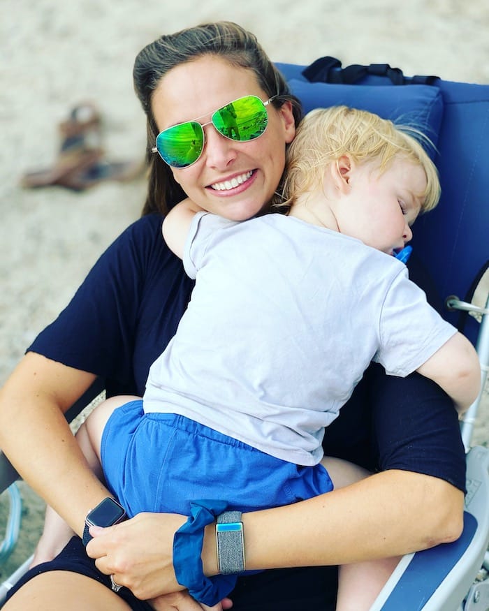 Toddler sleeping on Mom at the beach